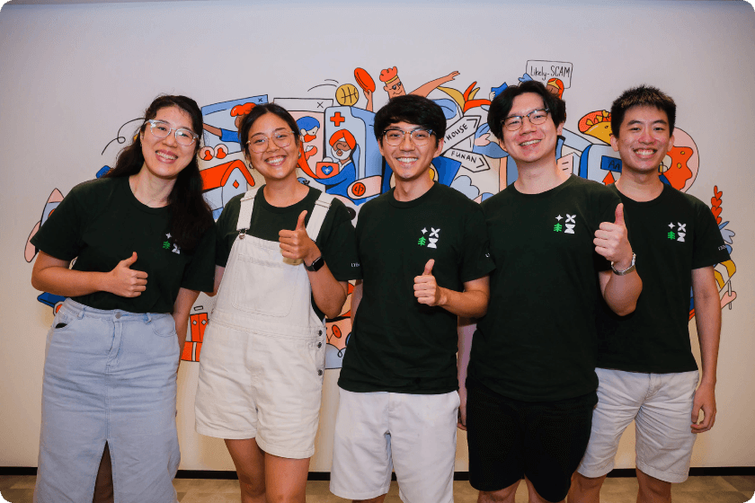 Five members of the original hackathon team posing together in matching green t-shirts